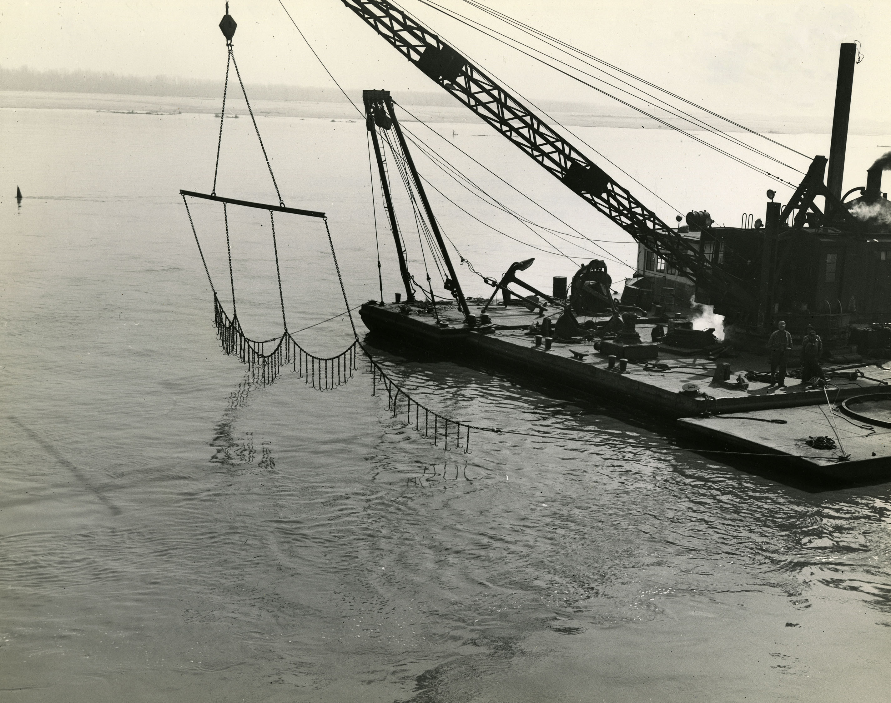 large boat with a woven chain net dangling over the water